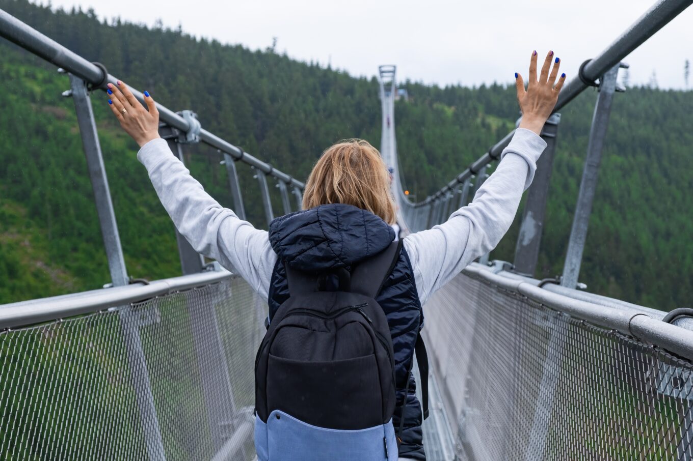 Zdjęcie przedstawia kobietę na moście Sky Bridge 721