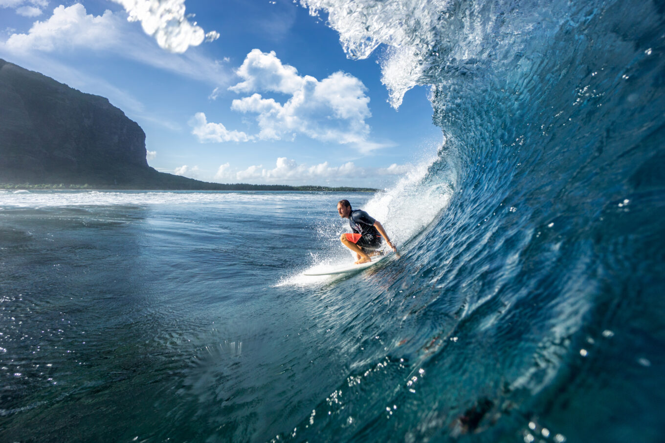 Surfer na fali, w tle wybrzeże