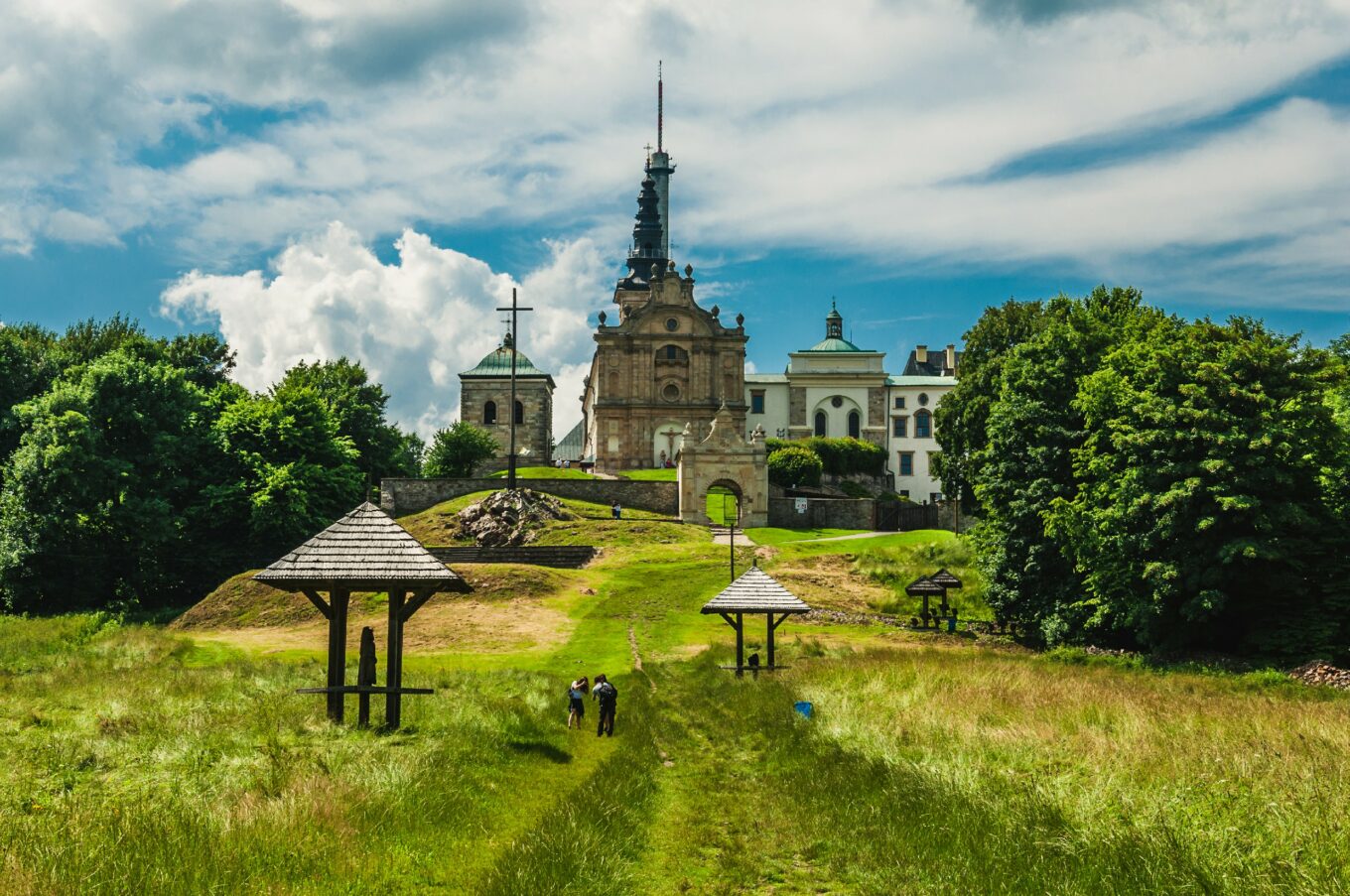 Wzgórze ze spacerującymi ludźmi, na górze kościół i zabudowa sakralna
