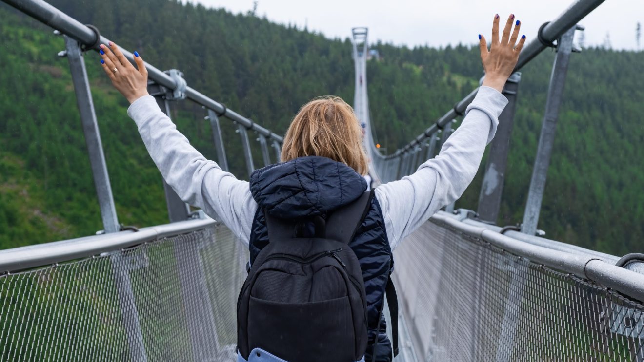 Zdjęcie przedstawia kobietę na moście Sky Bridge 721