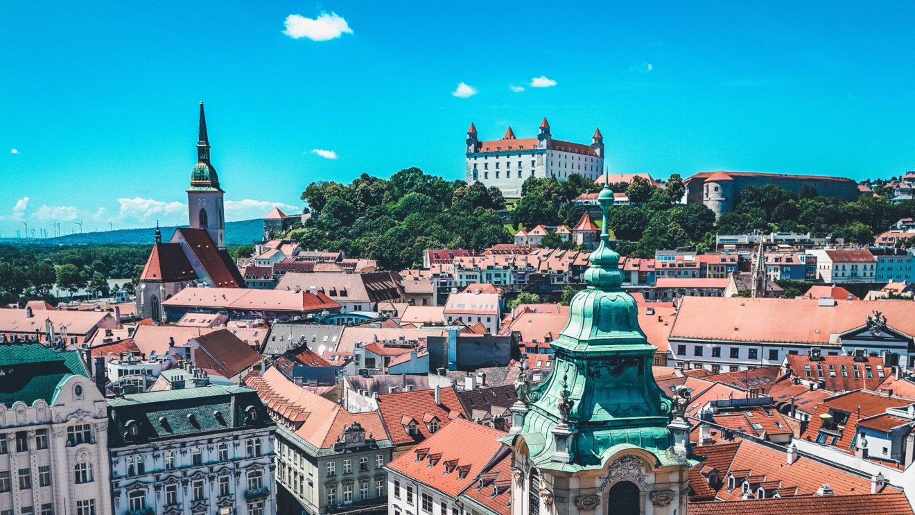 Zdjęcie przedstawia panoramę Bratysławy - widok na miasto oraz wznoszący się nad nim zamek