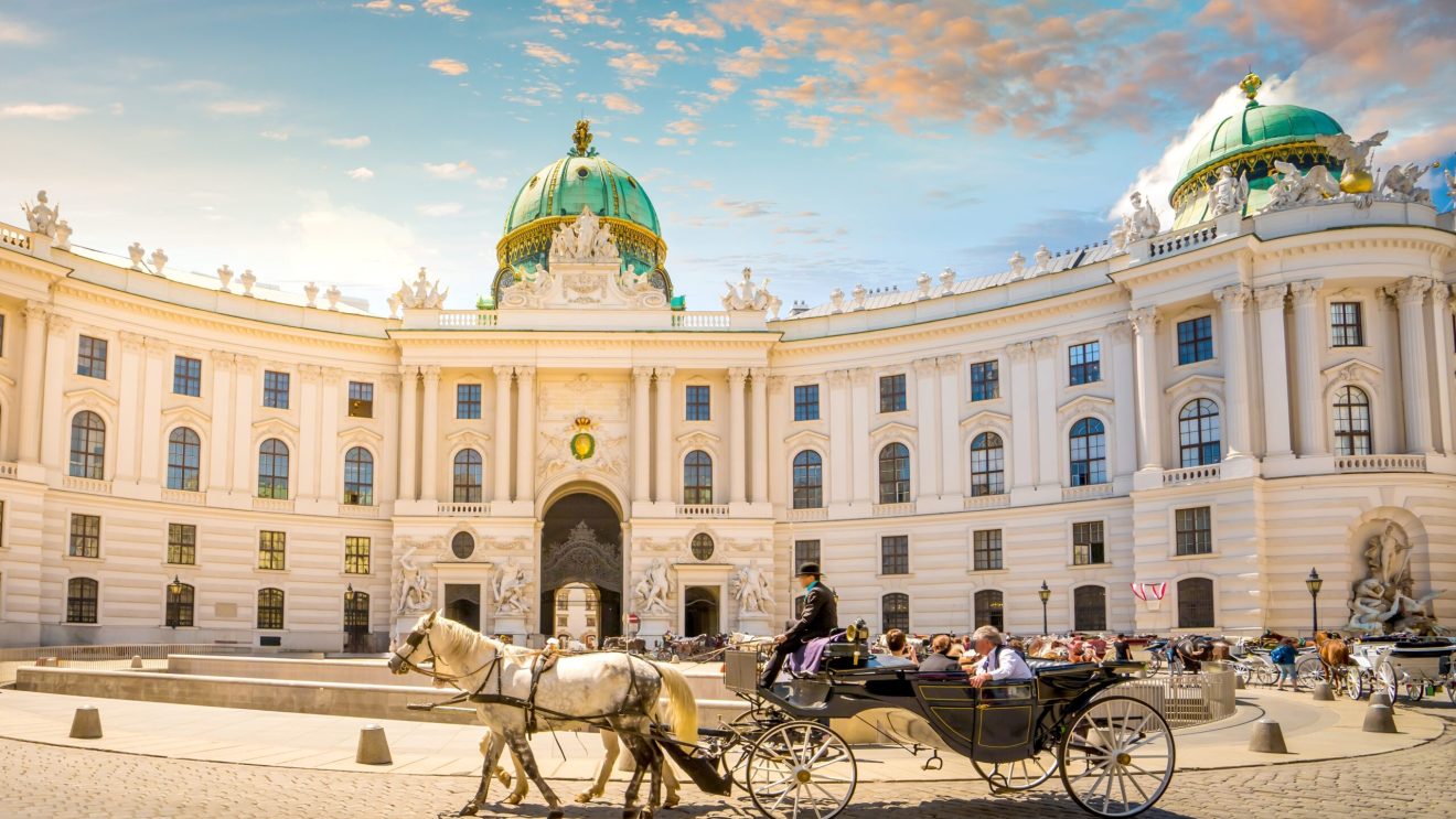 Zdjęcie przedstawia powóz konny, w tle zabytkowa architektura (Hofburg)