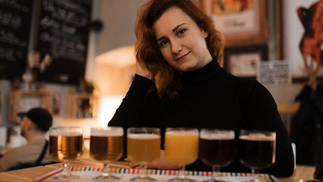 Zdjęcie przedstawia Czeszkę degustującą kilka rodzajów czeskich piw